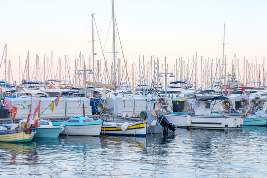 Yachts parked in Port of Cannes at sunset. Warm light reflecting on water. France beauties